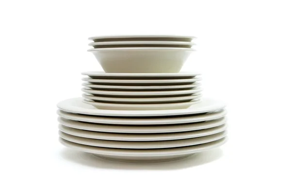 Stack of plain beige plates and saucers — Stock Photo, Image
