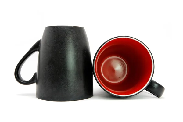 Two black coffee cups down and on side Royalty Free Stock Photos