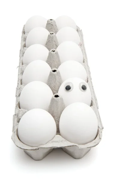 Huevo divertido con ojos entre docenas — Foto de Stock