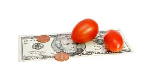 Small tomatoes on dollar bill with coins — Stock Photo, Image