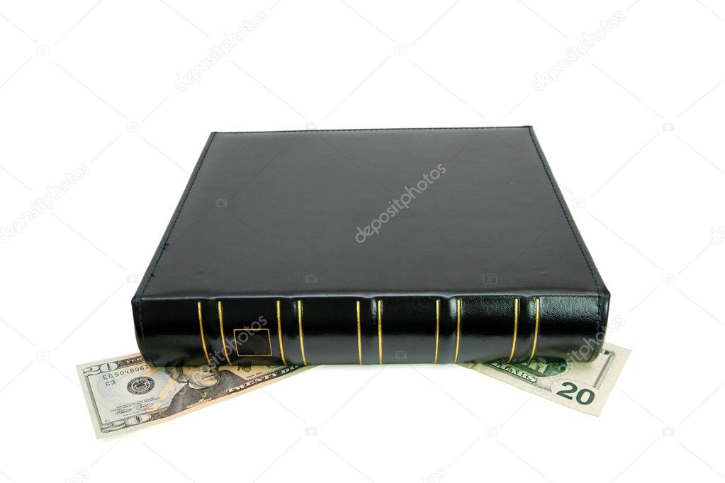 Thick black book on dollar bills