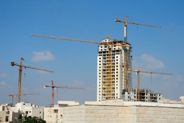 Six lifting cranes at construction site clipart