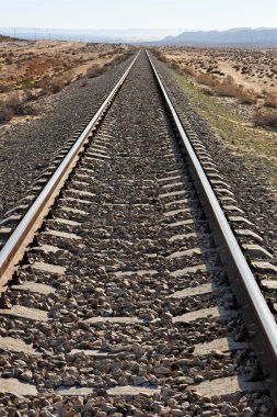 Straight railway in desert converging clipart