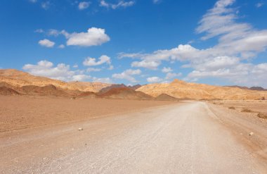 Road in the desert towards the rocks clipart