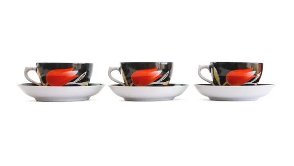 Fila de três xícaras de chá preto com pires — Fotografia de Stock