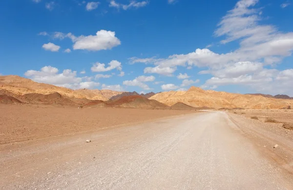 Strada nel deserto verso le rocce — Foto Stock