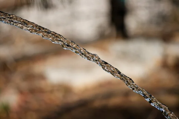 Strumień wody tworząc paraboli — Zdjęcie stockowe