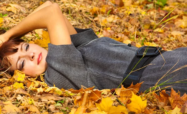 Γυναίκα είναι ξαπλωμένη σε φύλλα — Φωτογραφία Αρχείου