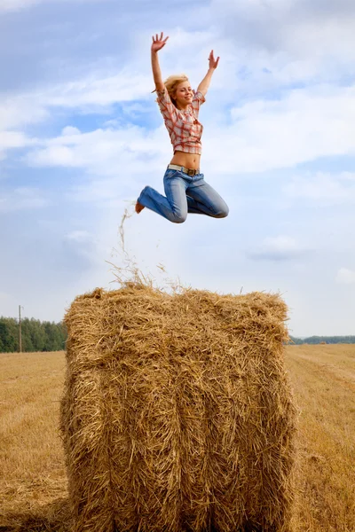 Девушка прыгает на соломенном рулете — стоковое фото