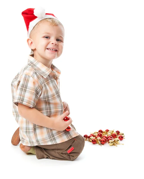 Little boy wearing a Santa hat and playi — Stock Photo, Image