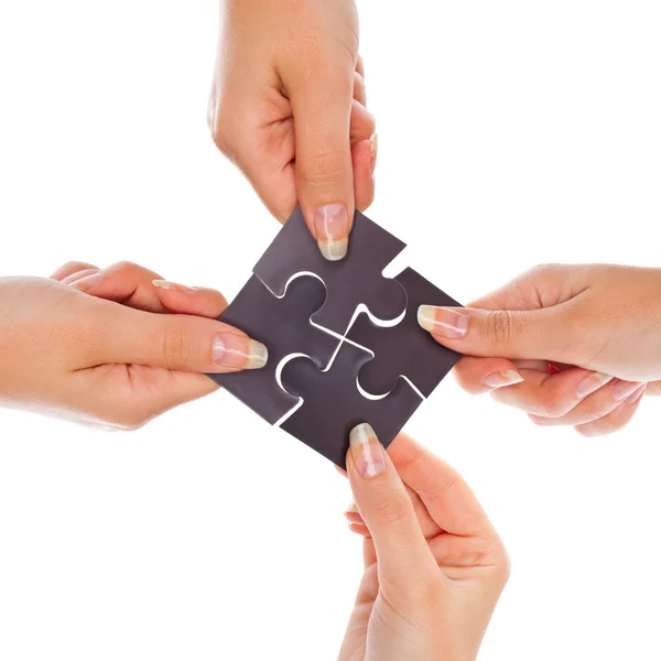 Mãos com quatro puzzles — Fotografia de Stock