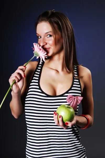 Frau mit Apfel und rosa Blume — Stockfoto
