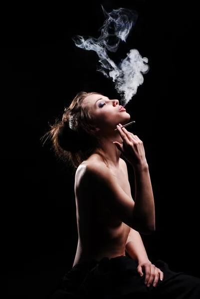 Bella ragazza nuda sta fumando al buio — Foto Stock