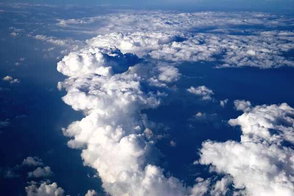 Panorama from the aircraft. Blue sky covered by clouds