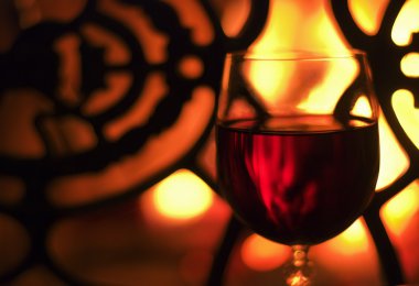 Glass of wine in front of the fireplace clipart