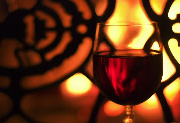 stock image Glass of wine in front of the fireplace