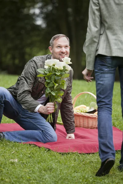 Homem conhece mulher com flores — Fotografia de Stock