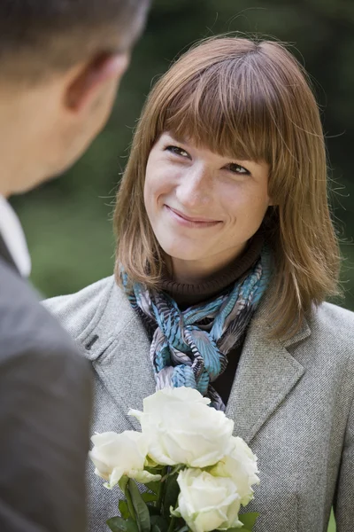 Woman with flowers smiling — Stock Photo, Image