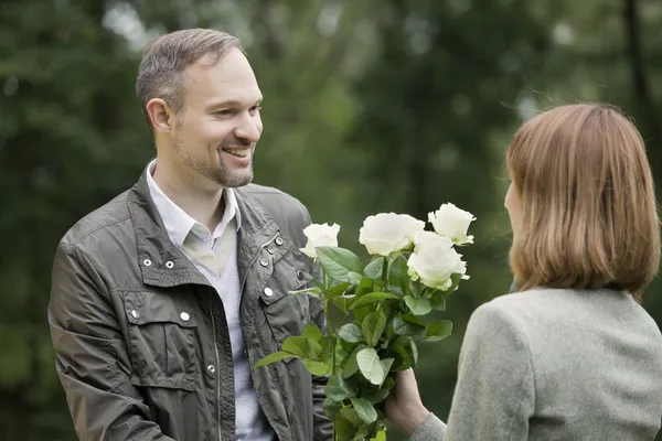 Man ger blommor kvinna — Stockfoto