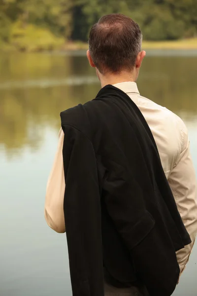 Mann mit Jacke am Ufer — Stockfoto