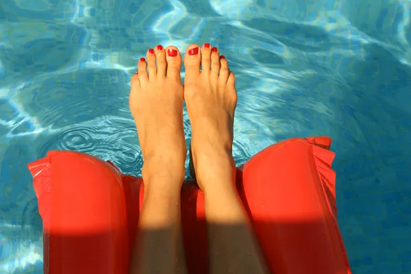 Femme pieds dans la piscine — Photo