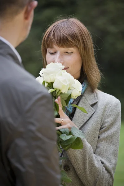 Mujer huele en las flores — Foto de Stock