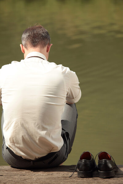 Грустный бизнесмен у реки

