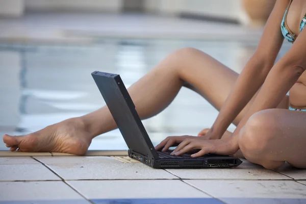 Frau tippt auf Laptop im Pool — Stockfoto