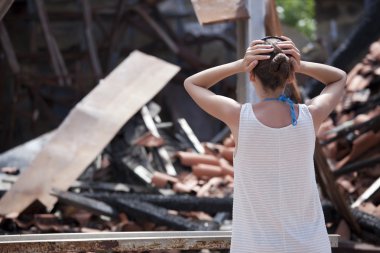 Woman in front of burned out house clipart