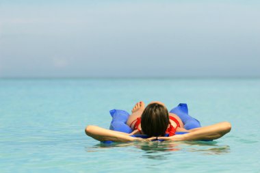 Woman lying on an air mattress clipart