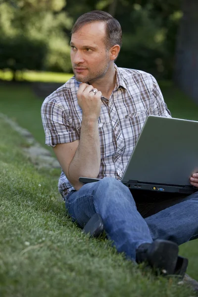 Pensando hombre con el ordenador portátil — Foto de Stock