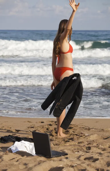 Женщина бросает куртку на пляж — стоковое фото