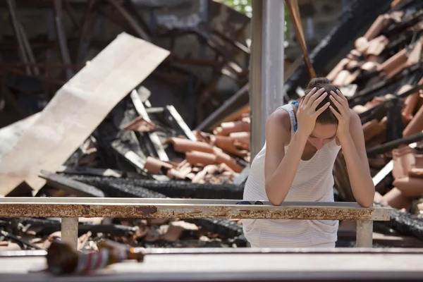 Traurige Frau und zerstörtes Haus — Stockfoto