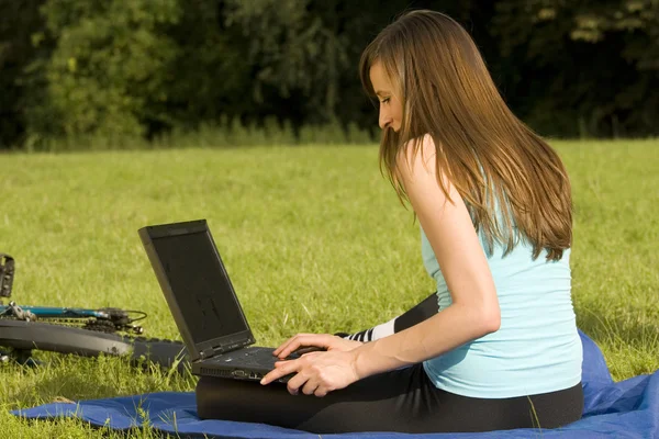 Estudante do sexo feminino trabalhando com laptop outdo — Fotografia de Stock