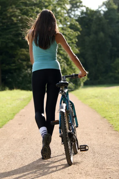Vrouw met fiets onderweg — Stockfoto