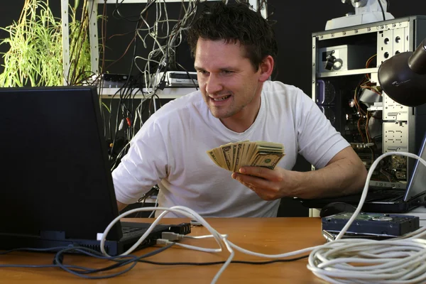 Людина з грошима, що працюють на комп'ютері — стокове фото