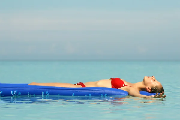 Woman sunbathing on an air mattress — Stok fotoğraf