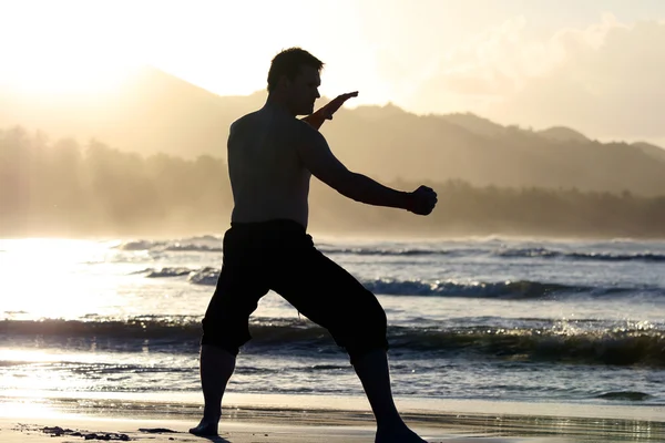 Man in strijd positie op het strand — Stockfoto