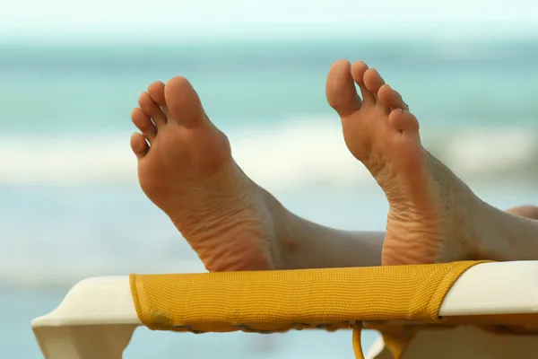 Kvinnliga fötter på stranden — Stockfoto