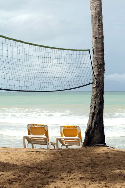 Vilstolar och volley netto på stranden — Stockfoto