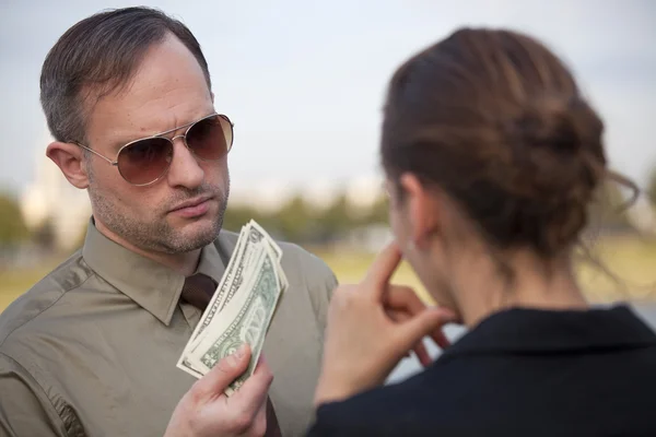 Мужчина предлагает деньги женщине — стоковое фото