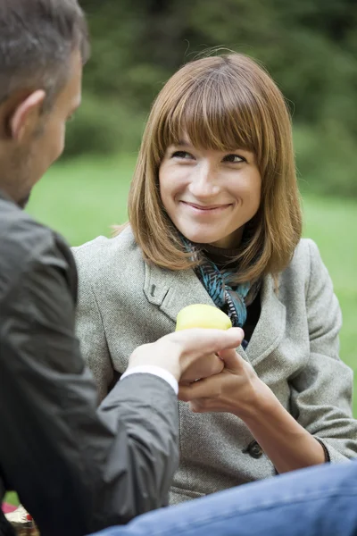 Man gives apple to woman — Stock Photo, Image