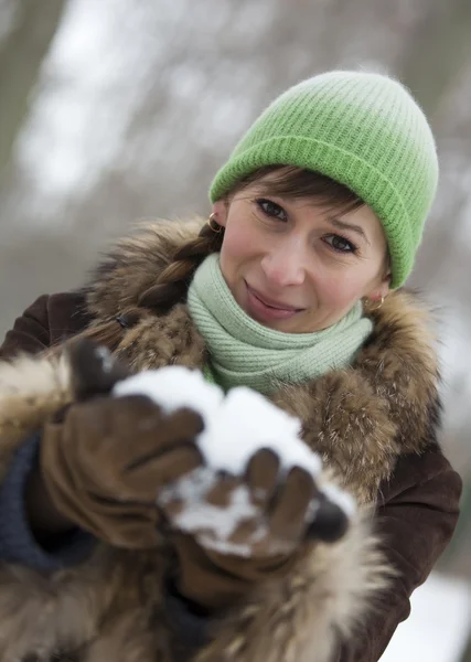Woman holding snow in hands — Stock Photo, Image