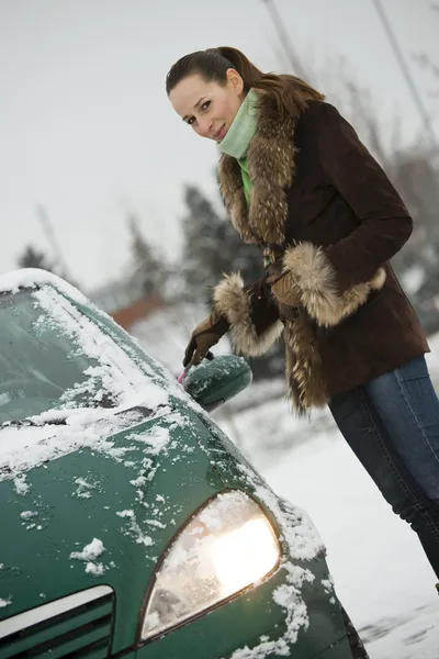 Woman scrubbing car in winter — Stock Photo, Image