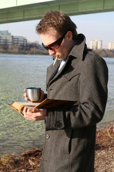 Hombre leyendo libro y fumando — Foto de Stock
