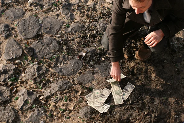 Counting cash on the ground — Stock Photo, Image