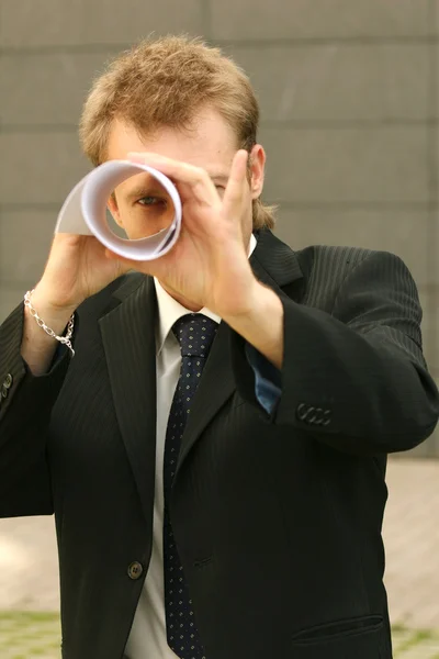 Hombre mirando a través del papel — Foto de Stock