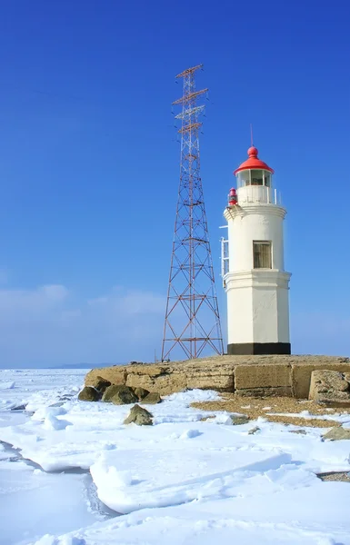 stock image Lighthouse on a clear winter day in a frozen sea