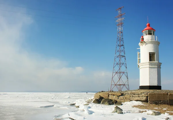 stock image Lighthouse on a clear winter day in a frozen sea AND CLOUDS