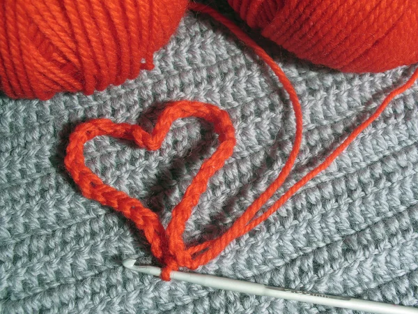 Knitted heart and red clews — Stock Photo, Image